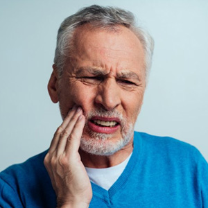 Man rubbing his aching jaw